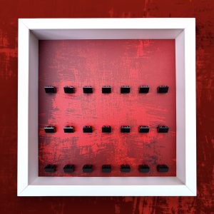 FRAMEPUNK Red Splatter LEGO minifigure display with black brick mounts. Compatible with 21 LEGO minifigures. White case. Placed on a red splatter background